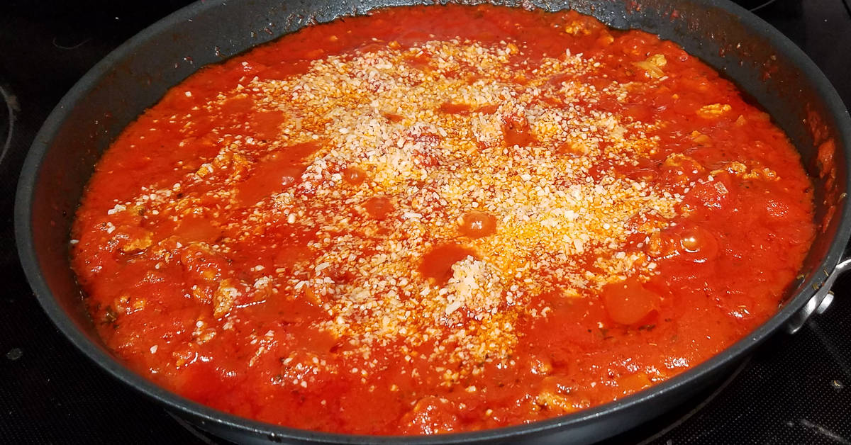 Bolognese Sauce parmesan cheese added to pan
