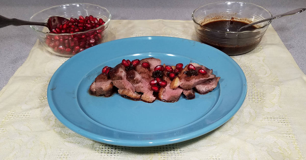 Roast Duck with Pomegranate Sauce served with sauce and pomegranate