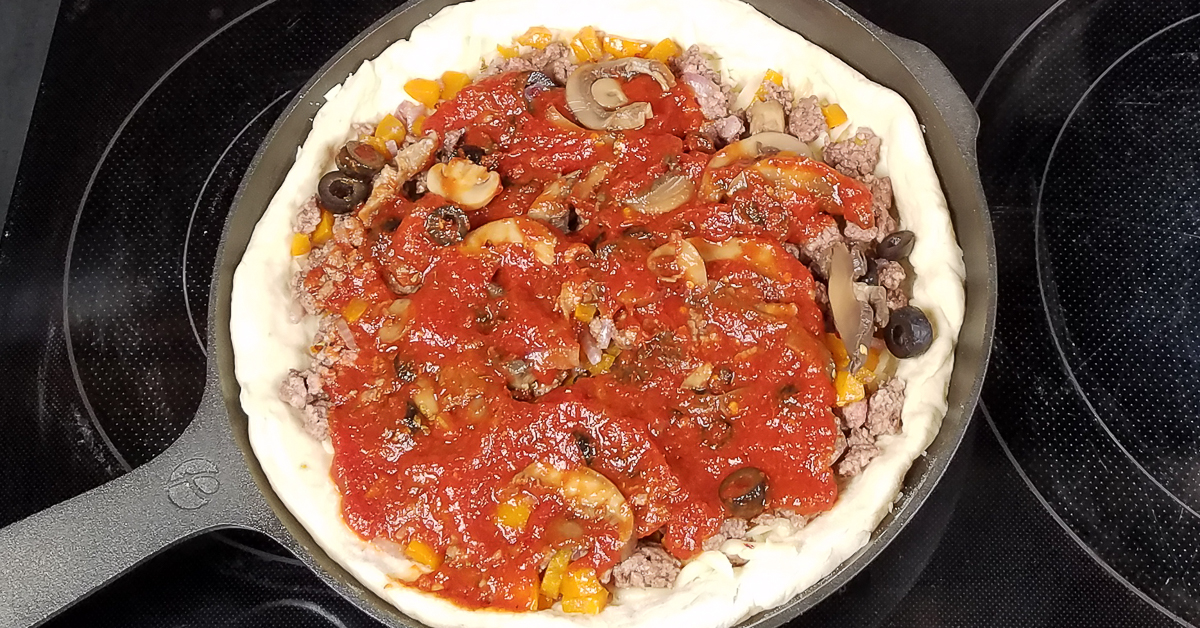 Chicago Style Stuffed Pizza sauce and spices added to pizza