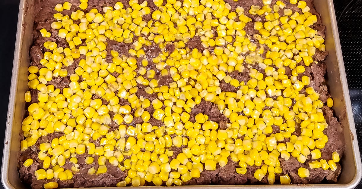 Layered Tex Mex Casserole layer of corn added to baking pan