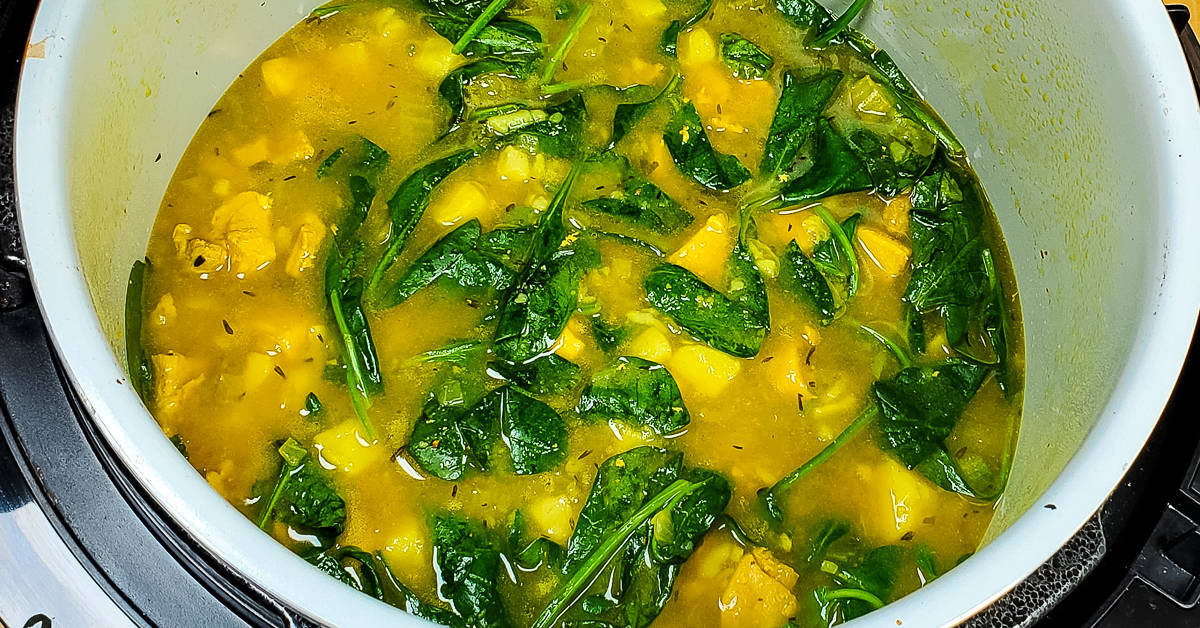 Turmeric Ginger Chicken Soup adding spinach