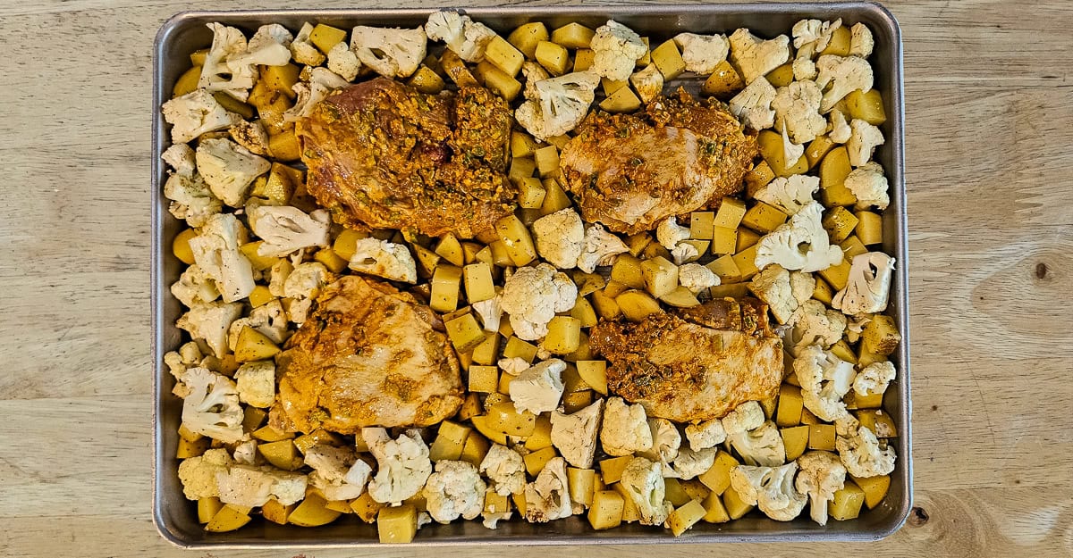 Sheet Pan Chicken Vindaloo chicken added to the pan