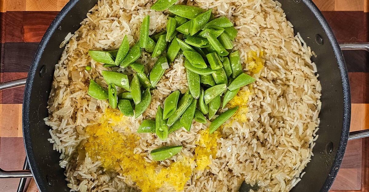 Indian Spiced Chicken Thighs With Coconut Rice chicken removed from the pan and peas and lemon added